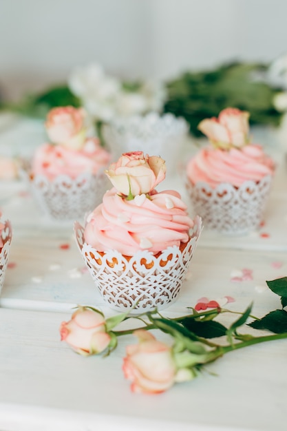 Délicieux muffins avec une crème rose décorée avec du vrai ros