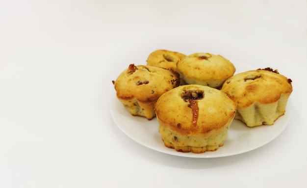 De délicieux muffins faits maison avec des pruneaux aux raisins secs et de la confiture à l'intérieur sur une assiette blanche Concept de cuisson à la maison