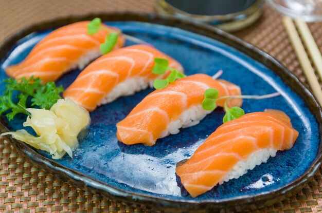 Délicieux nigiri au saumon de qualité supérieure sur une assiette bleue décorée à la main