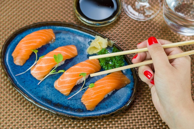 Délicieux nigirizushi au saumon de qualité supérieure sur une assiette bleue décorée à la main