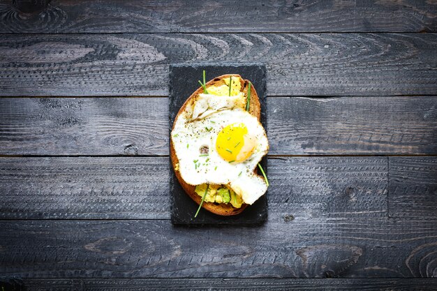 De délicieux œufs à l'avocat et des toasts au fromage tomate