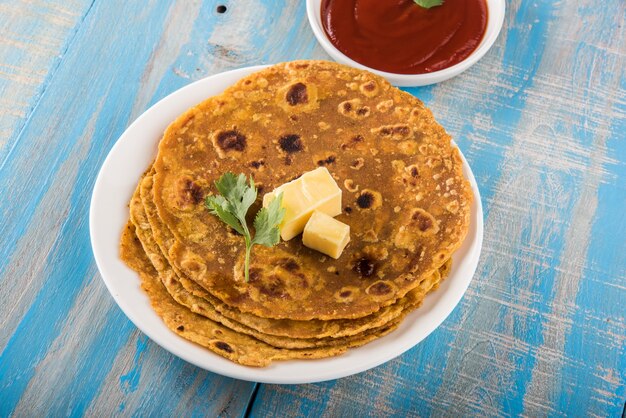 Délicieux paratha chaud avec du ghee et de la sauce tomate