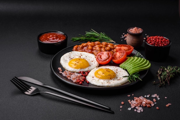 Délicieux petit-déjeuner anglais nutritif avec œufs au plat, tomates et avocat