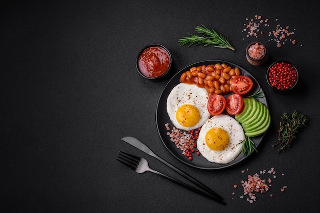 Délicieux petit-déjeuner anglais nutritif avec œufs au plat, tomates et avocat