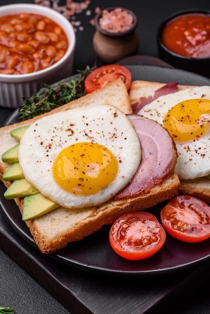 Délicieux petit-déjeuner anglais nutritif avec œufs au plat, tomates et avocat