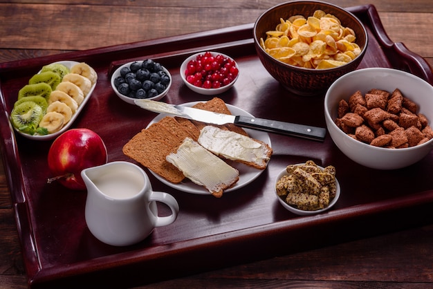 Délicieux petit déjeuner avec des croissants frais et des baies mûres sur une belle table en bois