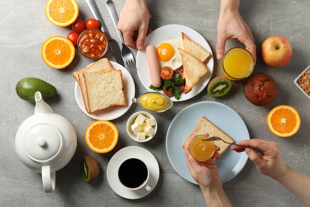 Délicieux petit déjeuner ou déjeuner. Table grise. Les gens mangent