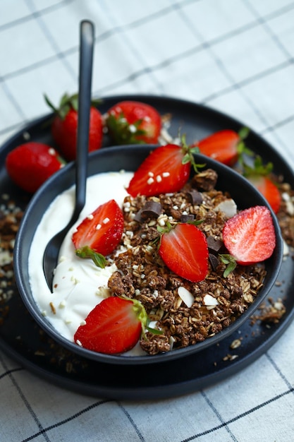 Délicieux petit-déjeuner sain ou dessert aux fraises yogourt blanc et granola au chocolat Aliments sains Dessert aux fraises Bol de petit-déjeuner