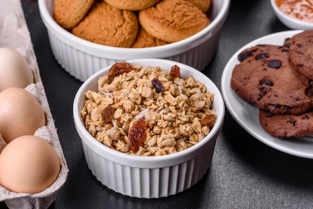 Délicieux petit-déjeuner sain et nutritif avec des œufs granola, des biscuits à l'avoine, du lait et de la confiture Une alimentation saine en début de journée