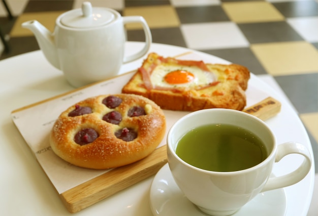 Délicieux petit déjeuner de thé vert chaud avec pain grillé et brioche