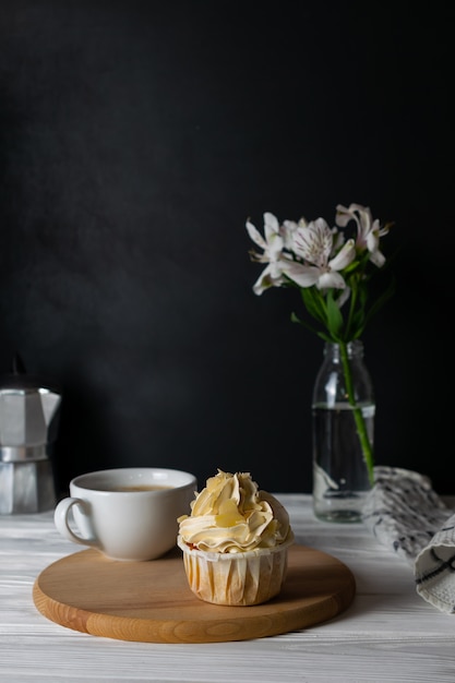 Délicieux petit gâteau au glaçage au goût d'amande avec une tasse de café