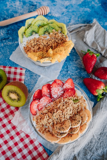 Délicieux petits déjeuners de yaourts aux fruits, muesli, chia et sirop.