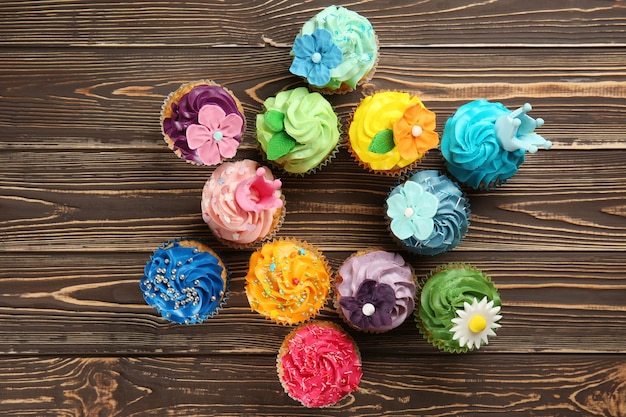 De délicieux petits gâteaux colorés sur une surface en bois