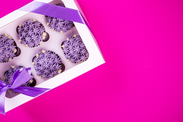 Délicieux petits gâteaux à la crème au lait caillé en forme de fleurs sur fond rose.