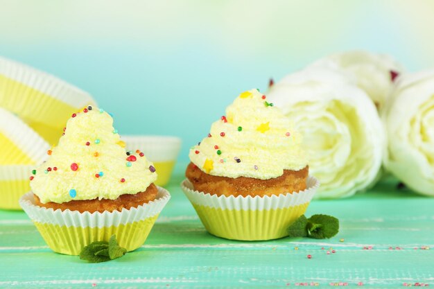 Délicieux petits gâteaux à la crème sur une table en bois bleue