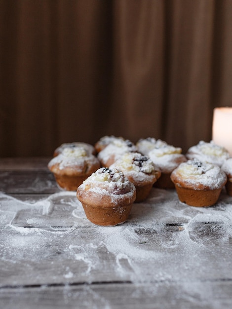 Délicieux petits gâteaux saupoudrés de sucre en poudre sur une vue de dessus de table en bois