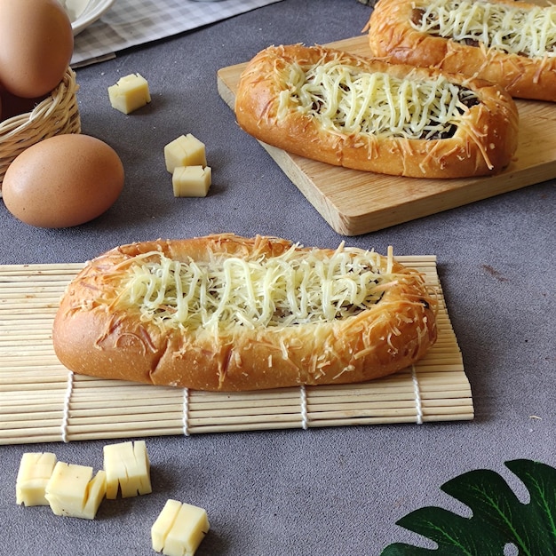 De délicieux petits pains au fromage et à la saucisse, des œufs sur une table en béton léger. boulangerie fraîche. petit-déjeuner. brea