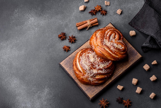 Délicieux petits pains à la cannelle croustillants frais saupoudrés de miettes de noix de coco sur une planche à découper en bois