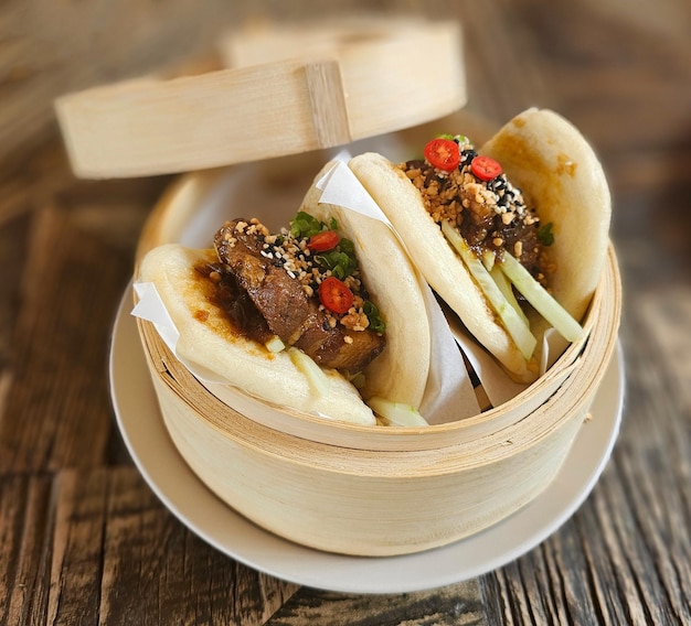 Photo des délicieux petits paons de bao remplis de sucrés de porc braisés et de légumes frais.