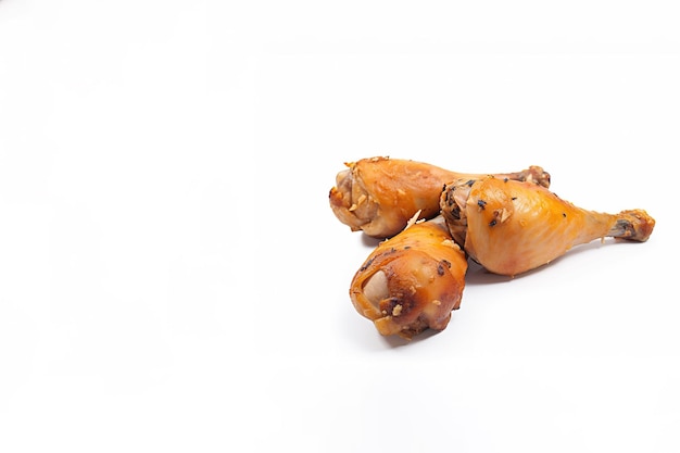 Délicieux pilons de poulet cuits au four dans la marinade de miel et de moutarde isolés sur fond blanc