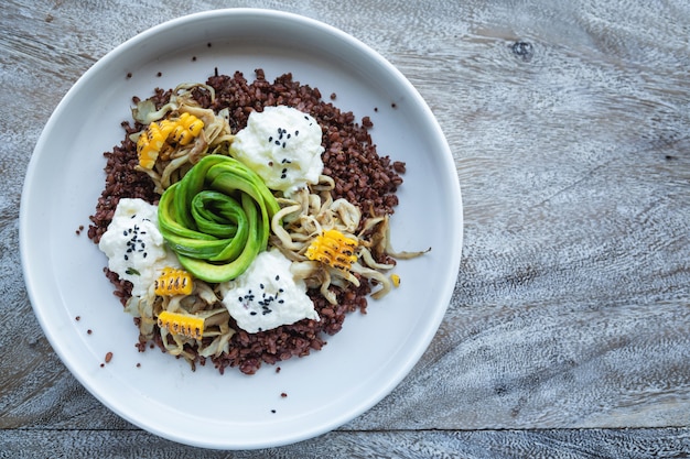 Délicieux plat avec avocat, fromage, maïs et grains de blé germé.