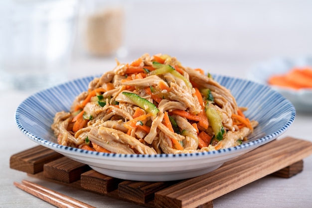 Délicieux plat fait maison salade de poitrine de poulet râpée, carotte et concombre avec sauce soja