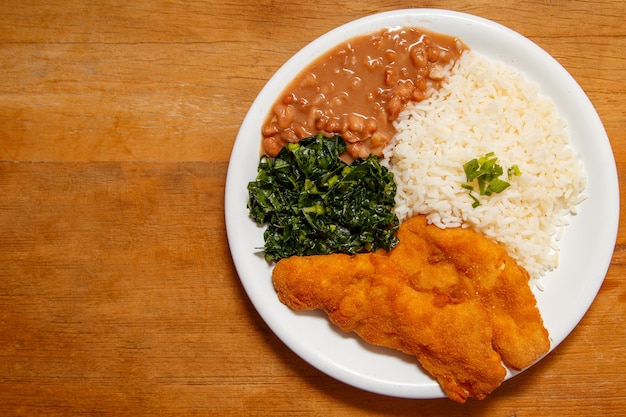 Délicieux plat de poulet pané avec riz, haricots et chou