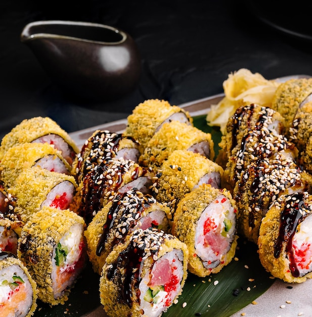 Photo un délicieux plateau de sushi sur un fond sombre