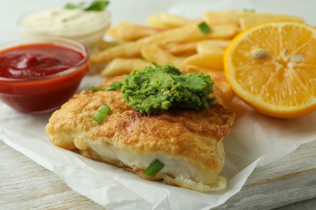 Délicieux poisson frit et frites sur tableau blanc