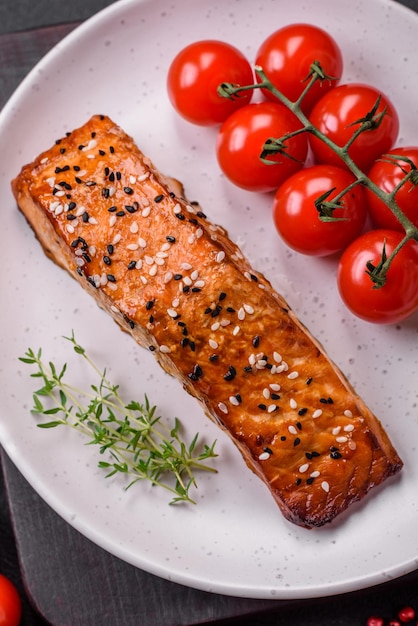 Délicieux poisson rouge grillé frais avec du sel, des épices et des herbes sur un fond de béton foncé