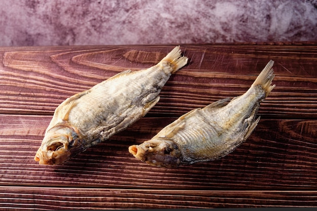 Un délicieux poisson salé se trouve sur une table en bois.