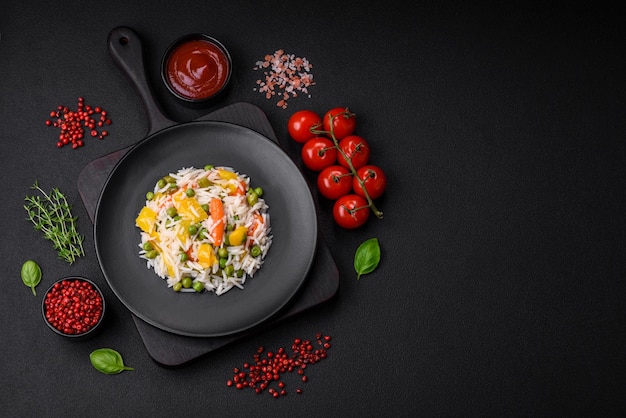 Délicieux riz blanc frais bouilli avec des légumes des carottes des poivrons et des asperges sur une assiette en céramique