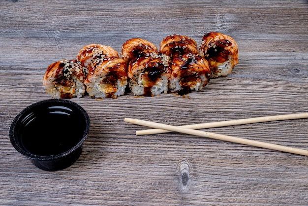 Délicieux rouleau de sushi frais traditionnel sur fond noir avec réflexion Rouleau de sushi au riz fromage à la crème avocat saumon sésame menu sushi de Philadelphie cuisine japonaise