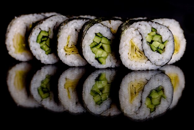 Photo de délicieux rouleaux de sushi sur un fond sombre.