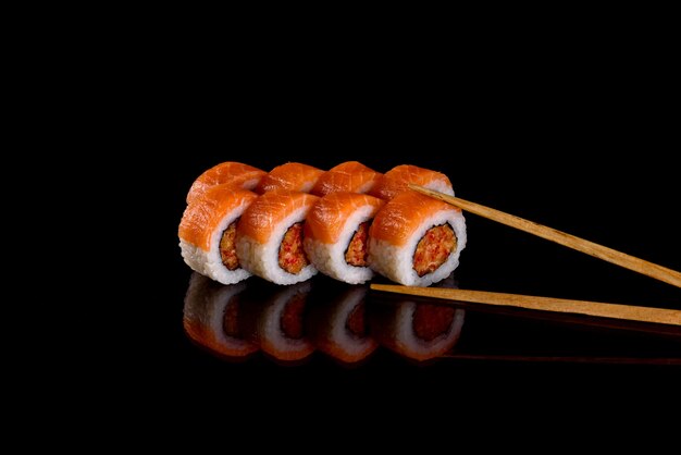 De délicieux rouleaux de sushi frais sur fond sombre