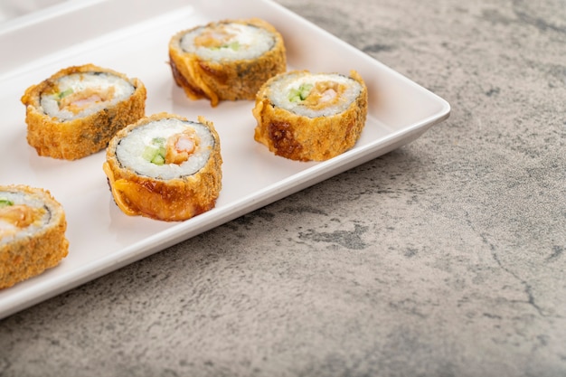 De délicieux rouleaux de sushi frais placés sur une table en pierre.