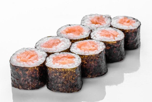 De délicieux rouleaux de sushi frais traditionnels sur fond blanc avec reflet