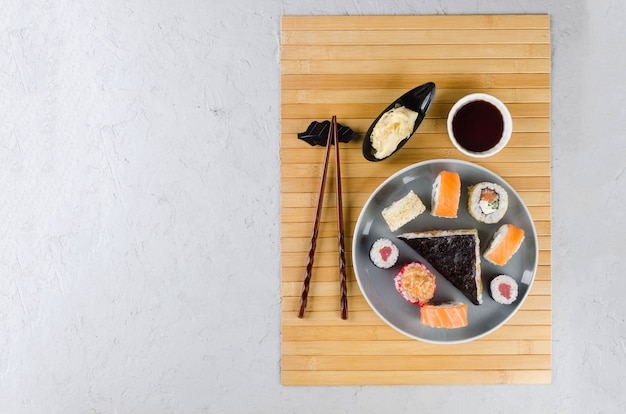 Délicieux rouleaux de sushi sertis de sauces, baguettes, gingembre sur table. Service de livraison Cuisine japonaise