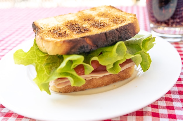 Délicieux sandwich au jambon grillé, tomates et laitue.