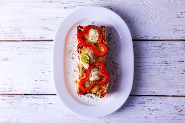 Délicieux sandwich aux légumes et fromage sur plaque sur fond de bois