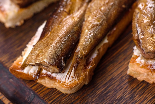 Délicieux sandwich frais aux sprats avec du beurre de pain grillé croustillant et du concombre