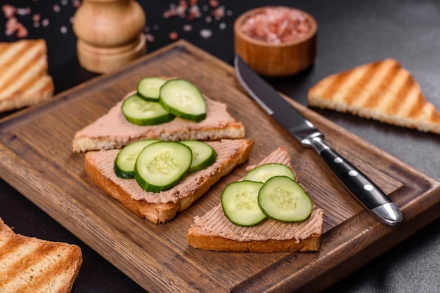 Délicieux sandwich frais avec du pâté de foie de poulet avec du beurre de pain grillé croustillant et du concombre