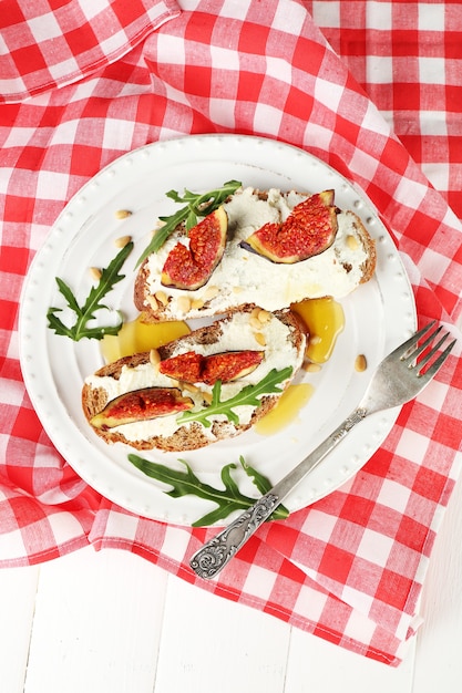 Délicieux sandwichs aux figues sucrées et fromage cottage sur assiette