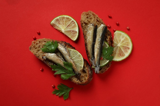 Délicieux sandwichs aux sprats sur fond rouge