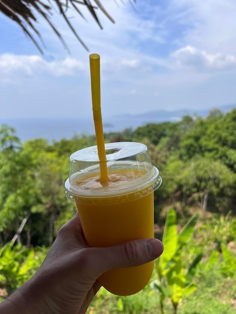 Un délicieux shake de mangue dans la main d'un homme