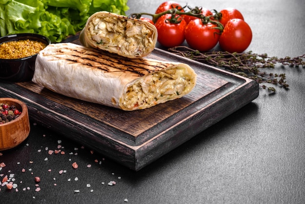 Délicieux shawarma frais avec de la viande et des légumes sur une table en béton foncé. Restauration rapide, cuisine turque