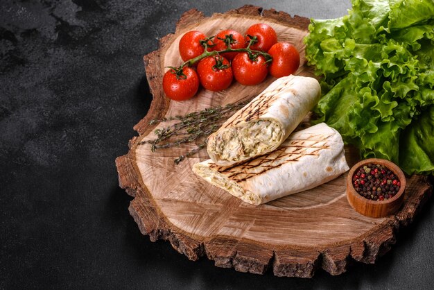 Photo un délicieux shawarma frais avec de la viande et des légumes sur une table en béton sombre