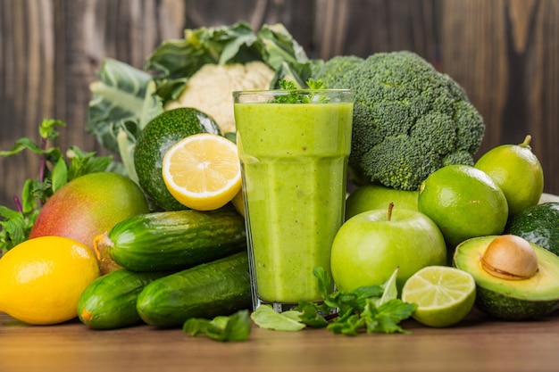 Délicieux smoothie vert sain avec des fruits et légumes sur table