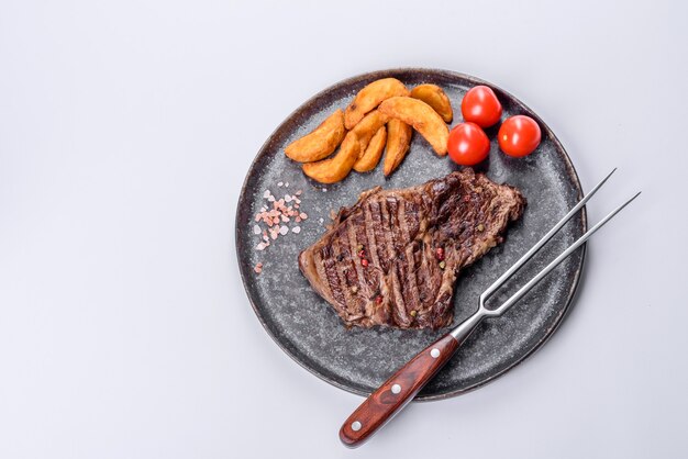 Délicieux steak de boeuf frais juteux avec des épices et des herbes sur fond blanc. Plats grillés