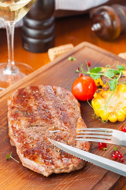 Délicieux steak de boeuf juteux sur une planche de bois